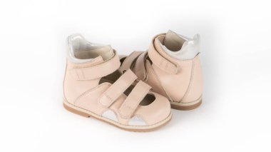 Beyaz arkaplanda bej renkli ortopedik sandaletler