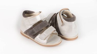 Beyaz arkaplanda beyaz ve kahverengi ortopedik sandaletler