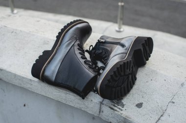 Yüksek kadınlar ya da unisex ayakkabıları. Ayakkabı bağcıklı bir çift bot. Günümüz kadınlarının gündelik ayakkabı modası. Koyu gri parlak deri ayakkabılar..