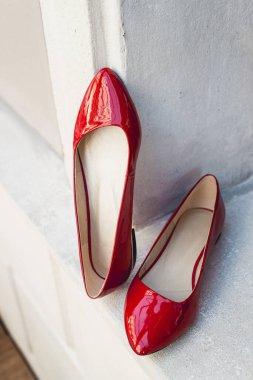 Beyaz ahşap bir rafta kırmızı deri kadın ayakkabıları. Moda, asgari moda konsepti, kadın ayakkabıları, aksesuarlar. Kırmızı kadınlar deri ayakkabılar.