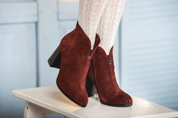 Botas de gamuza marrón para mujer. piernas delgadas de mujer en medias blancas — Foto de Stock