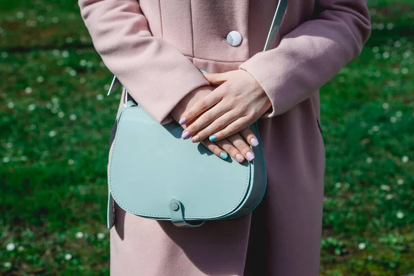 Stylish woman in beige coat with small blue handbag. — Stock Photo, Image