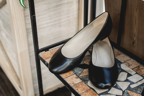 Schwarze Frauenschuhe aus Leder in einem Regal. Modekonzept, Damenschuhe, Accessoires. — Stockfoto