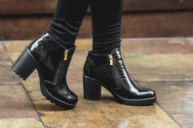 Kadınların siyah deri çizmeleri. Sokak fotoğrafı. Moda reklam ayakkabıları fotoğrafları..