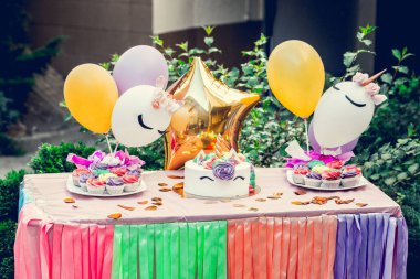 Tatlı kremalı ve mumlu renkli doğum günü pastası. Farklı renkte muffin masasında servis edilen bir pasta..