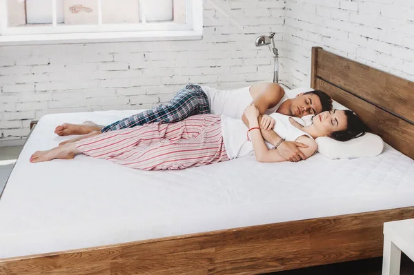 Jeune couple amoureux en pyjama dans le lit — Photo