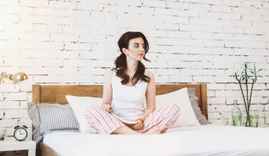 Yatağında kitap olan arkadaş canlısı genç bir kadın.