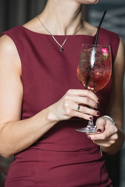 Mulher detém relaxante coquetel rosa alcoólico com uma rosa no topo — Fotografia de Stock