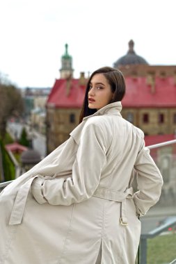 Şık bir ceket giyen güzel, şık bir hanımın açık hava portresi. Manken yan bakıyor. Kadın moda konsepti. Şehir yaşam tarzı. Kapat..