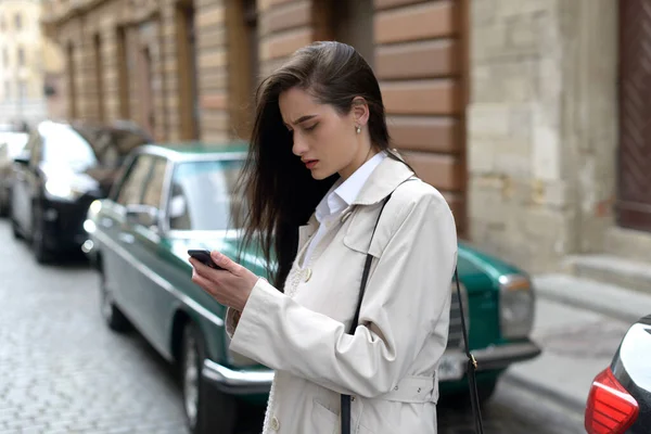 Uma mulher na rua usa um telemóvel. compras online. Utilização de aplicações móveis. — Fotografia de Stock
