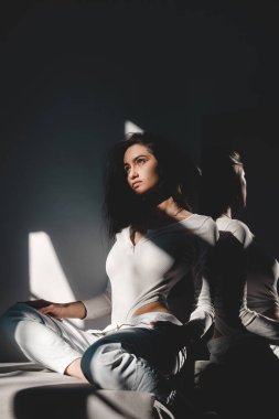 Güneş ışığında poz veren beyaz elbiseli güzel bir kadının portresi. Siyah uzun saçlı. şehvet ve şefkat