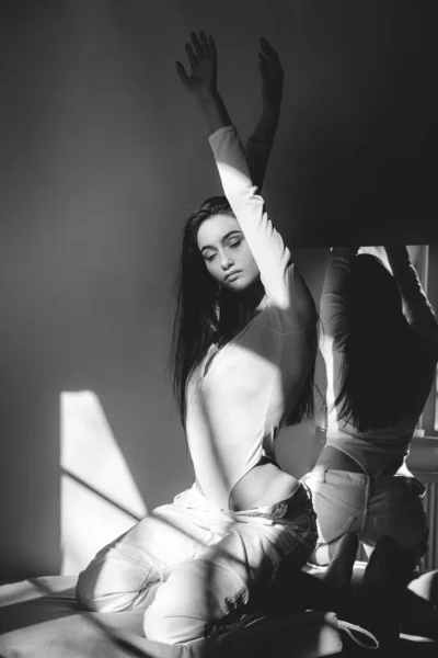 Ritratto di bella donna gentile in un body bianco in posa al sole. Capelli lunghi neri. sensualità e tenerezza — Foto Stock