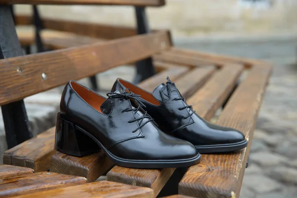 Botas de cuero para mujer de cerca. negro brillante oxford zapatos de estilo en un banco de madera — Foto de Stock