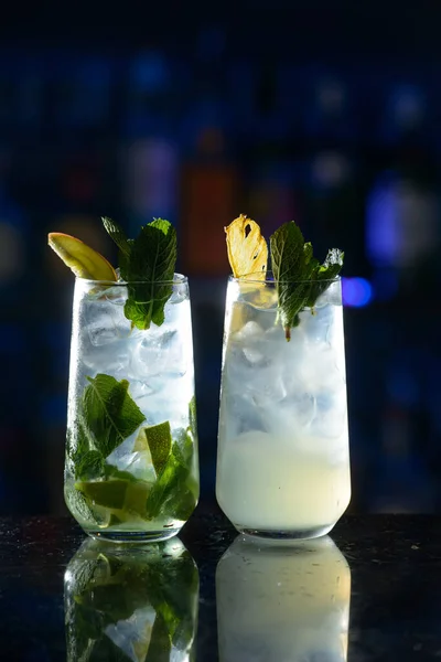Coquetéis alcoólicos de verão mojito com rum, hortelã, limão e gelo, ferramentas de bar, fundo cinza, foco seletivo — Fotografia de Stock