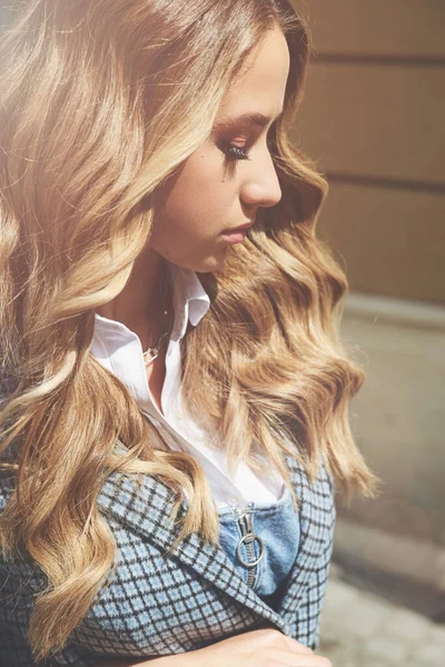 Jeune femme à la mode avec des cheveux blonds habillés en chemisier blanc et haut en denim donc manteau à carreaux posant. — Photo