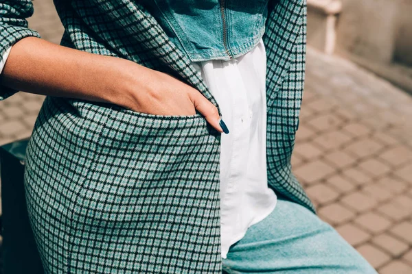 Hermosas manos femeninas con manicura azul y elemento de elegante abrigo a cuadros — Foto de Stock