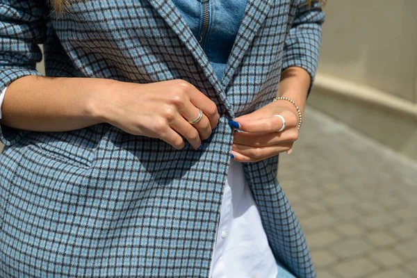 Belle mani femminili con manicure blu ed elemento di elegante cappotto a scacchi — Foto Stock