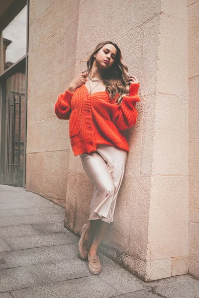Portrait de femmes à la mode en pull orange et robe beige posant dans la rue — Photo
