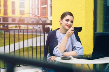 Sınıfa hazırlanmak için dizüstü bilgisayar kullanan güzel, mutlu bir bayan öğrenci..