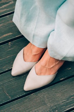 Mavi pamuklu pantolon ve bej ayakkabılı kadın bacakları