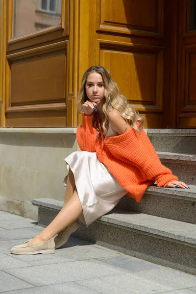 Portrait de femmes à la mode en pull orange et robe beige posant dans la rue — Photo