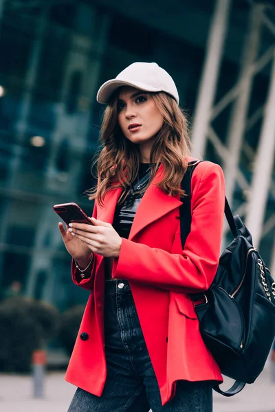 Una mujer en la calle usa un teléfono móvil. compras en línea. uso de aplicaciones móviles. — Foto de Stock