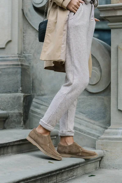 Retrato de mujeres de moda en pantalones beige y gabardina posando en las escaleras de piedra — Foto de Stock