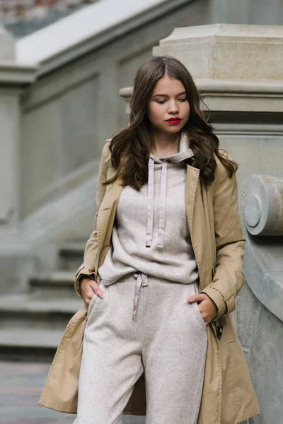 Portrait de femmes à la mode en costume de sport beige et trench coat posant dans la rue — Photo