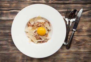 Makarna Carbonara parmesan ve sarısı karanlık wo üzerinde beyaz plaka üzerinde
