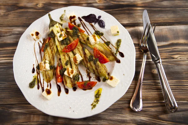 Kızarmış sebze iliği ve beyaz tabakta domates