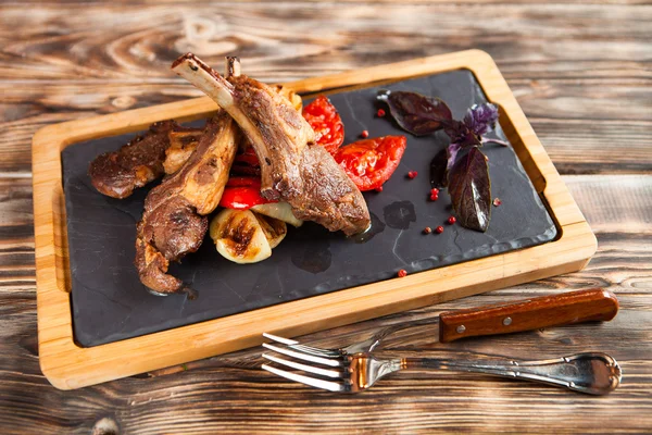 Côtes d'agneau rôties aux épices et légumes sur plaque noire d — Photo