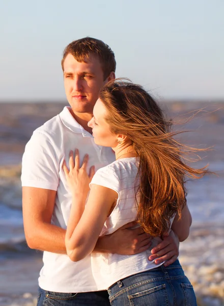 Attraktives glückliches junges Paar beim Kuscheln am Strand. — Stockfoto