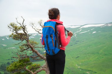 Genç kadın Traveler dağlar'da sırt çantası yürüyüş ile