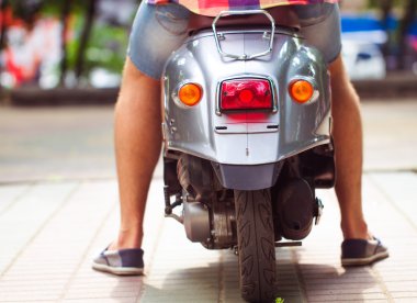 adam sürme eski retro scooter bir şehir sokakta. yakın çekim