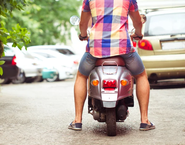 शहरातील रस्त्यावर जुना रेट्रो स्कूटर चालविणारा माणूस. बंद करा — स्टॉक फोटो, इमेज