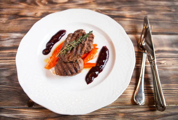 Deliciosa carne a la parrilla con verduras con romero sobre madera oscura — Foto de Stock