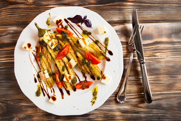 Kızarmış sebze iliği ve beyaz tabakta domates