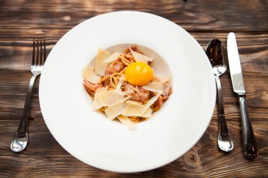 İtalyan makarna Carbonara parmesan ve sarısı üzerinde beyaz plaka üzerinde