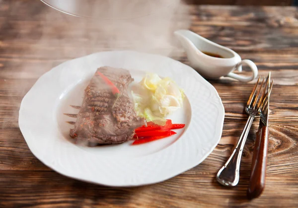 Kött på ett glas cloche med grönsaker, ger om stea — Stockfoto