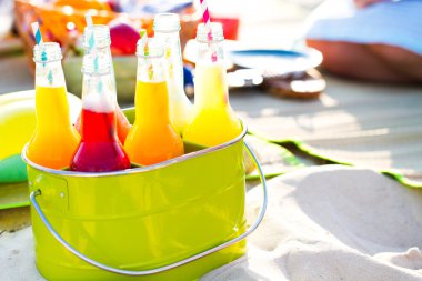 Limonata, renkli bir yeşil kova içinde duran şişe 