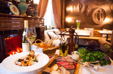 Beyaz şarap, meze, salata bir tabloda restoranda servis edilir