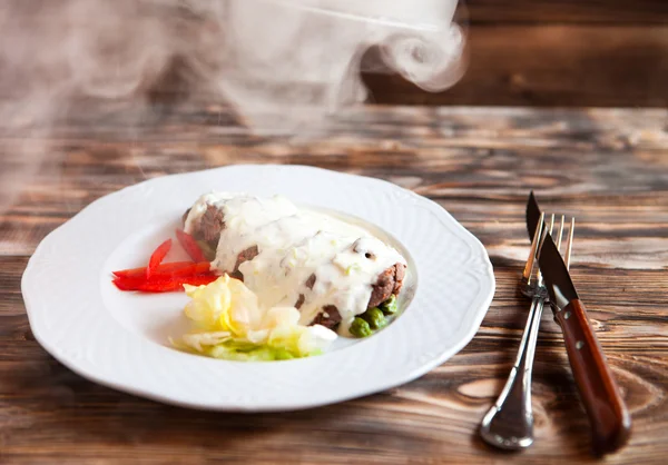 Viande sous une cloche de verre avec des légumes, donnant sur le stea — Photo