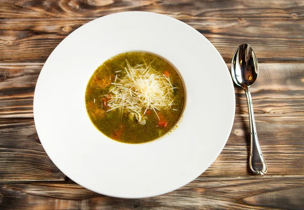 Plato con sopa de verduras que está decorado con queso rallado — Foto de Stock