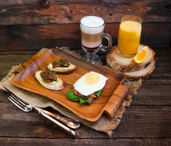 Latte Macchiato with Coffee Beans, Two eggs and bacon toasts and — Stock Photo, Image