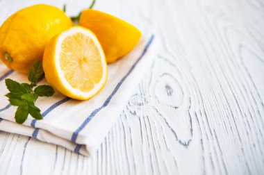 Beyaz ahşap zemin üzerine nane yaprakları ile sulu limon. Kenneth'in