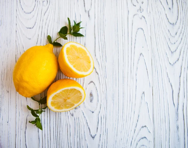 Šťavnatých citronů s listy máty na bílém pozadí dřevěná. Lemo — Stock fotografie