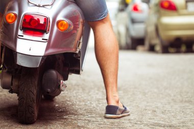 adam sürme eski retro scooter bir şehir sokakta. yakın çekim