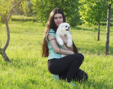 Beautiful girl with a young dog enjoying a beautiful day