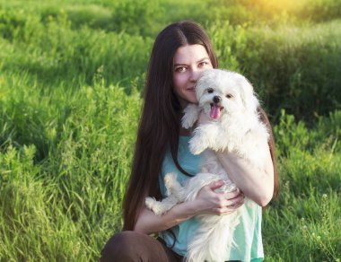Beautiful brunette with a young dog enjoying a beautiful day
