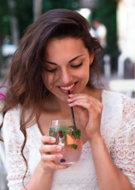 beautiful smiling woman drinking cold lemonade berry, outdoor